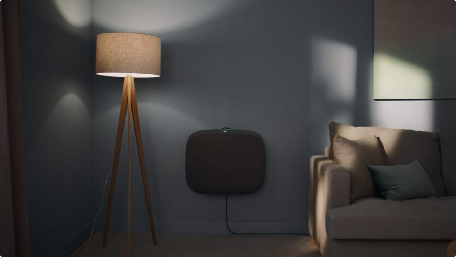 Floor lamp next to an air purifier in a dark living room.