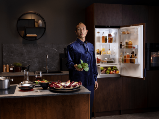 Un homme à côté d'un frigo AEG