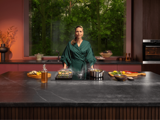 Woman standing next to hob in kitchen